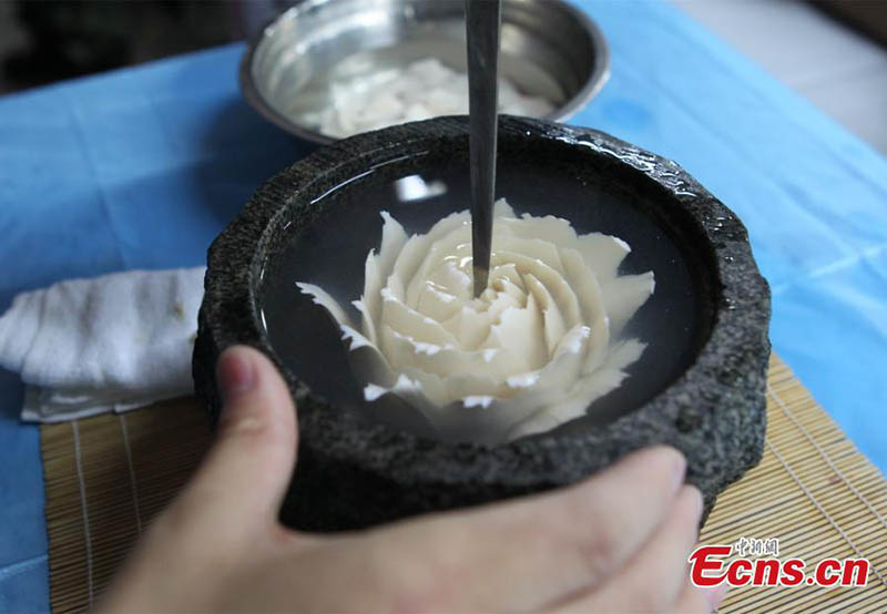 Cozinheiro chinês produz caligrafia com igredientes de culinária e utensílios de cozinha