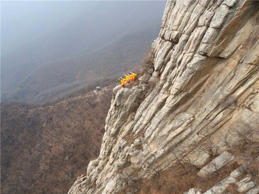 Praticantes de artes marciais treinam kung fu de Shaolin numa escarpa