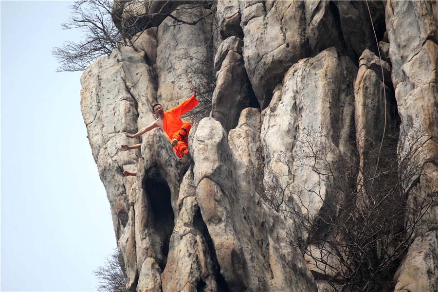 Praticantes de artes marciais treinam kung fu de Shaolin numa escarpa