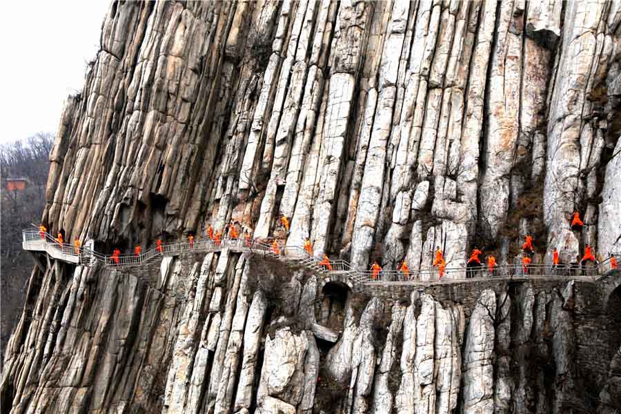 Praticantes de artes marciais treinam kung fu de Shaolin numa escarpa