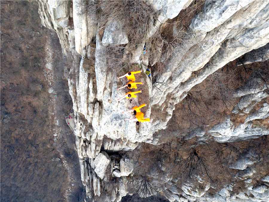 Praticantes de artes marciais treinam kung fu de Shaolin numa escarpa