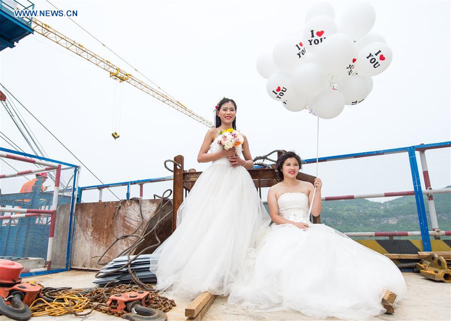 Casais chineses tiram fotos de casamento em ponte suspensa