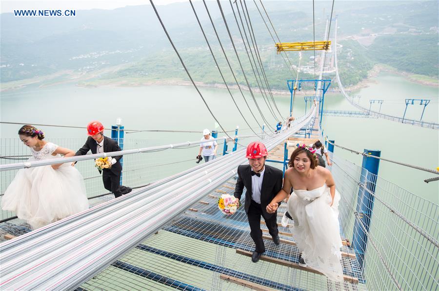 Casais chineses tiram fotos de casamento em ponte suspensa