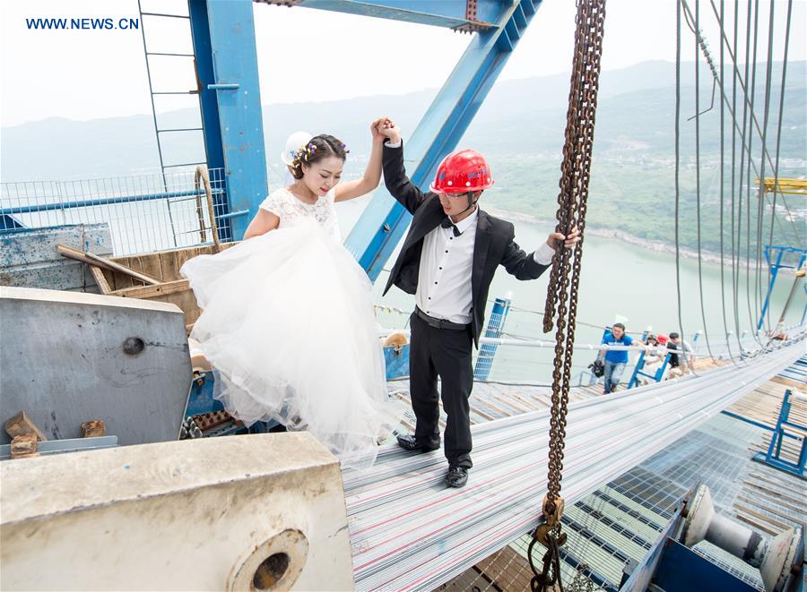 Casais chineses tiram fotos de casamento em ponte suspensa