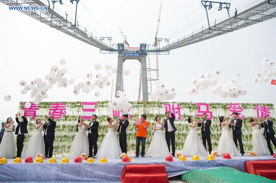 Casais chineses tiram fotos de casamento em ponte suspensa