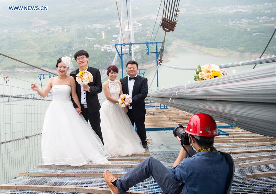 Casais chineses tiram fotos de casamento em ponte suspensa