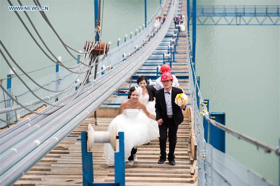 Casais chineses tiram fotos de casamento em ponte suspensa