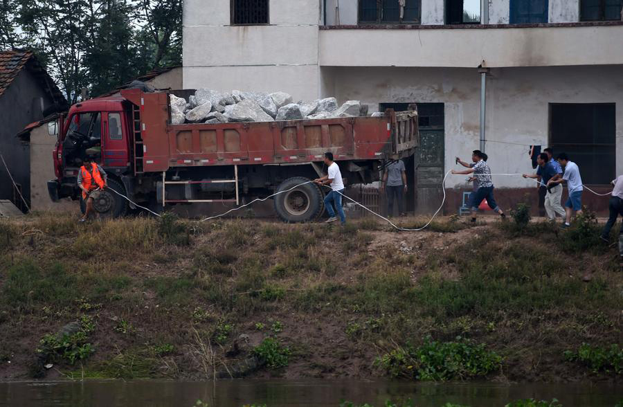 Socorristas arriscam a vida utilizando caminhões para bloquear inundações