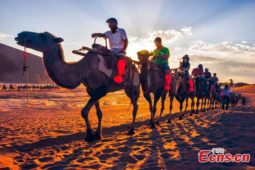 Turistas visitam Montanha Mingsha no noroeste da China