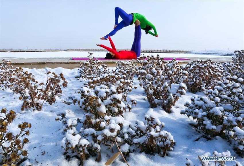 Entusiastas de ioga praticam sobre manto de neve na província de Gansu