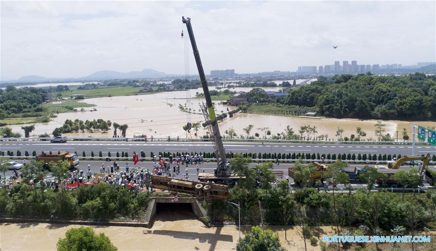 Caminhão reboque é utilizado para bloquear passagem de água em região alagada em Changsha