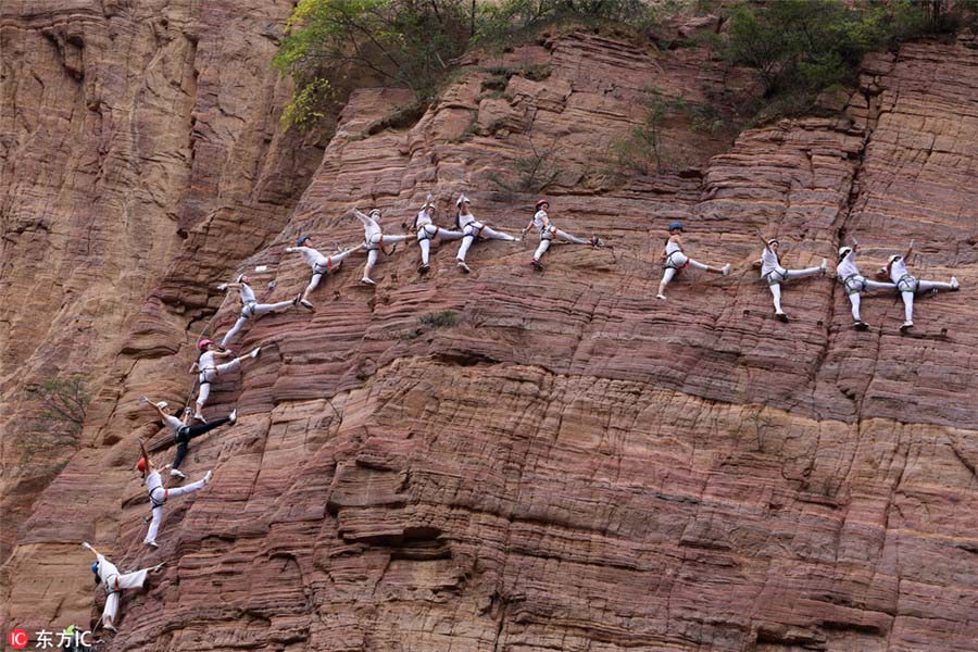 Entusiastas praticam yoga em penhasco