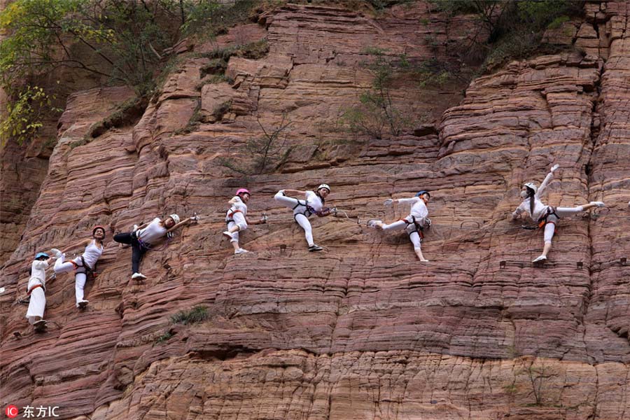 Entusiastas praticam yoga em penhasco