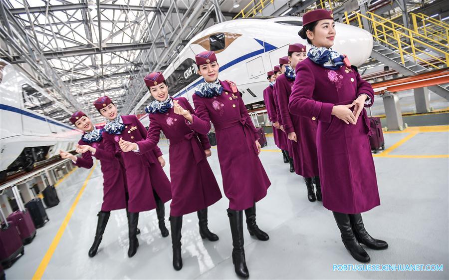 Membros da tripulação dos trens-bala da ferrovia Xi'an-Chengdu posam para fotos