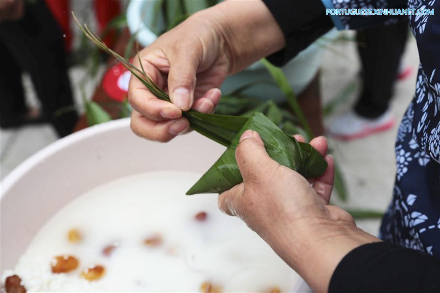 Pessoas preparam Zongzi com a chegada do próximo Festival do Barco-Dragão