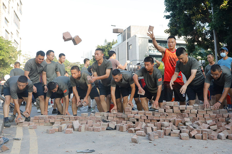 Moradores limpam destroços de protesto deixados durante fim de semana caótico