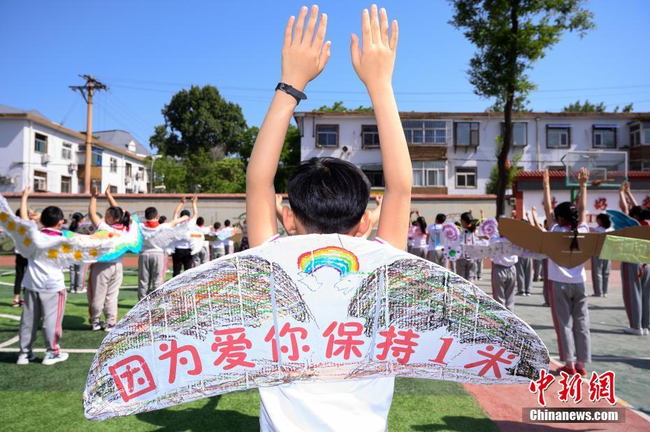 China: alunos de escola primária usam “asa de um metro” para manter distanciamento

