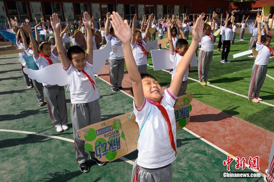 China: alunos de escola primária usam “asa de um metro” para manter distanciamento

