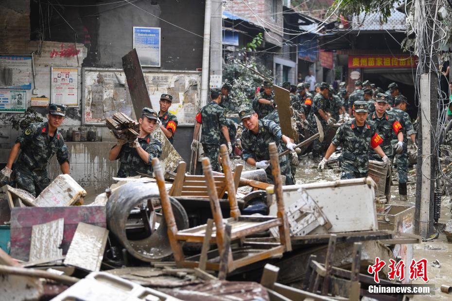 Oficiais e soldados limpam lama depois da inundação em Chongqing