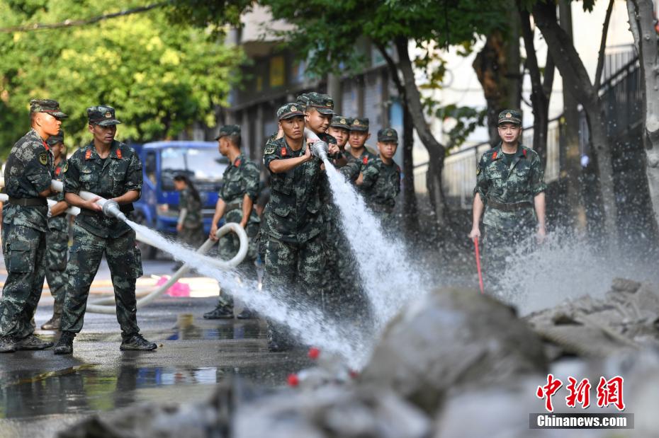 Oficiais e soldados limpam lama depois da inundação em Chongqing