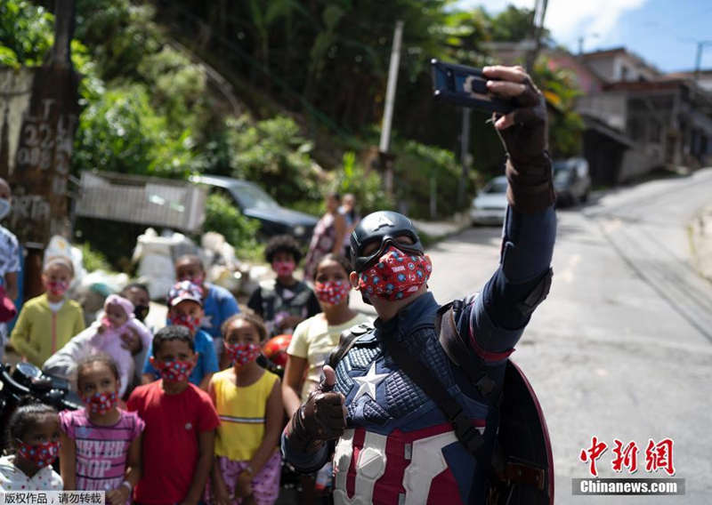 Policiais brasileiros vestidos de super-heróis interagem com crianças