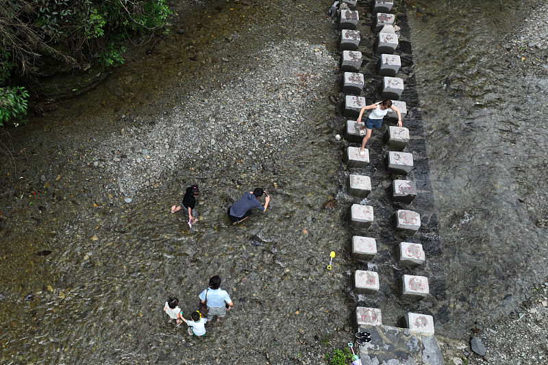 Turistas brincam com água na barragem para passar calor, sudoeste da China