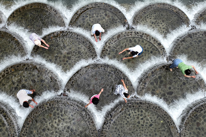 Turistas brincam com água na barragem para passar calor, sudoeste da China