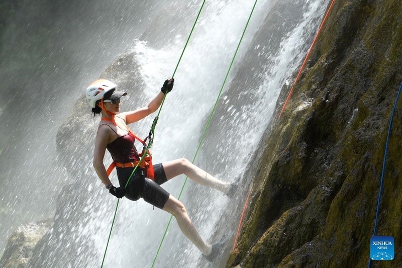 Guizhou: cascata atrai turistas em busca de aventura no verão